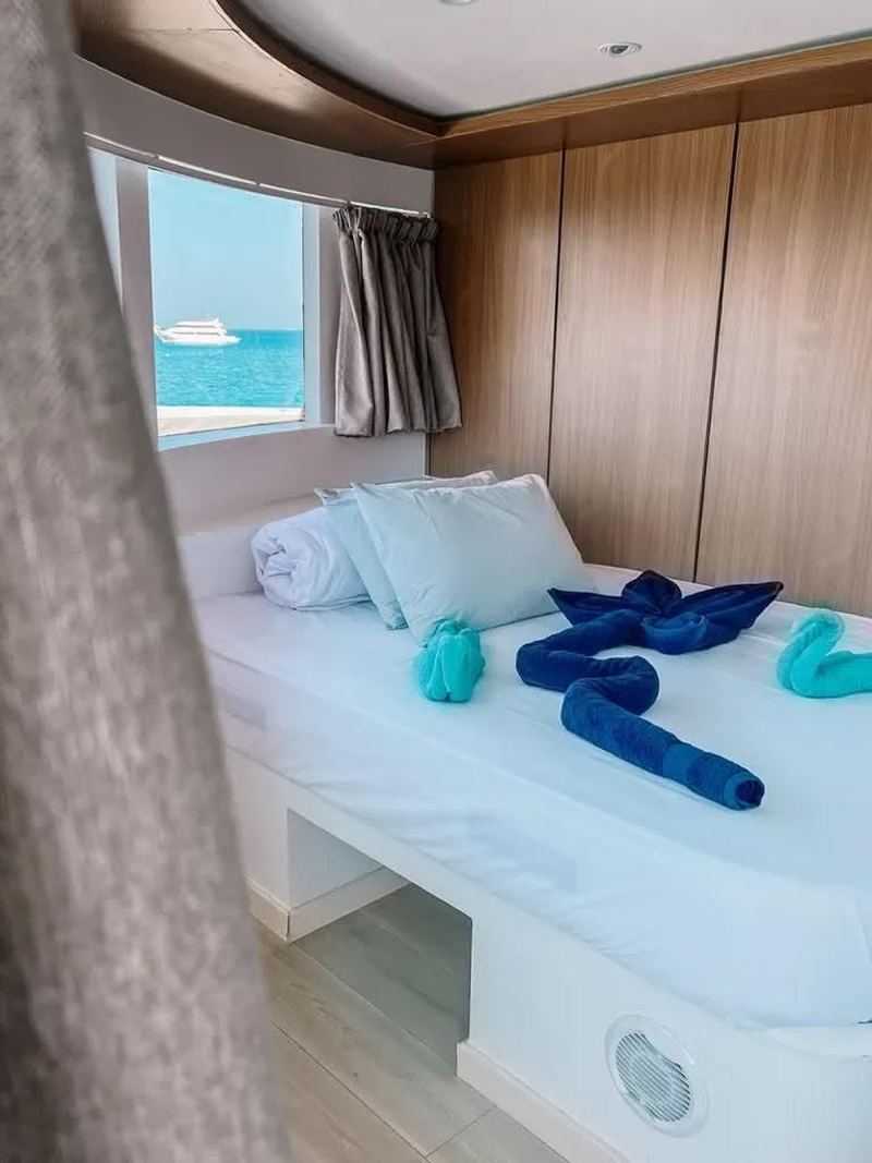Cabin with window, bed and folded towels