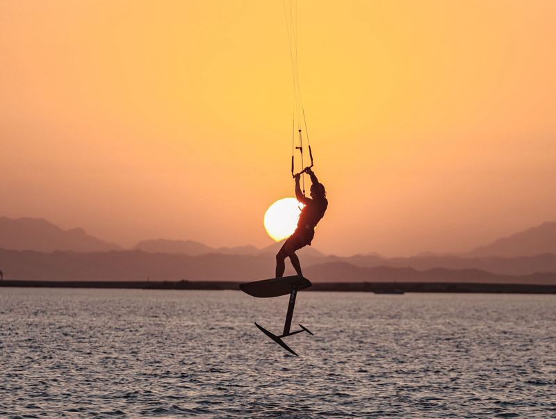 Kite foiler silhouette in front of the setting sun