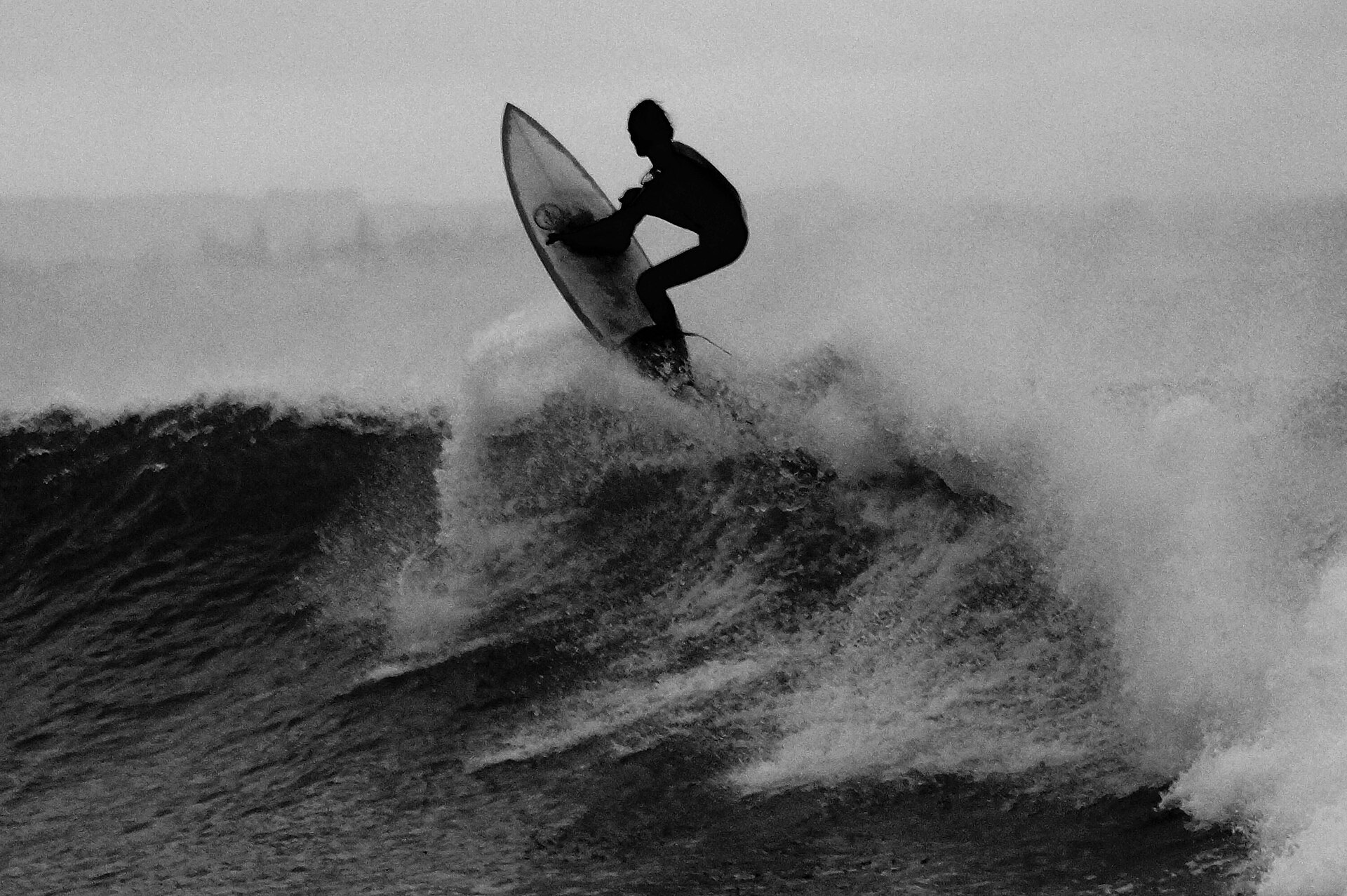 Monochrome surfer on wave (Unsplash)