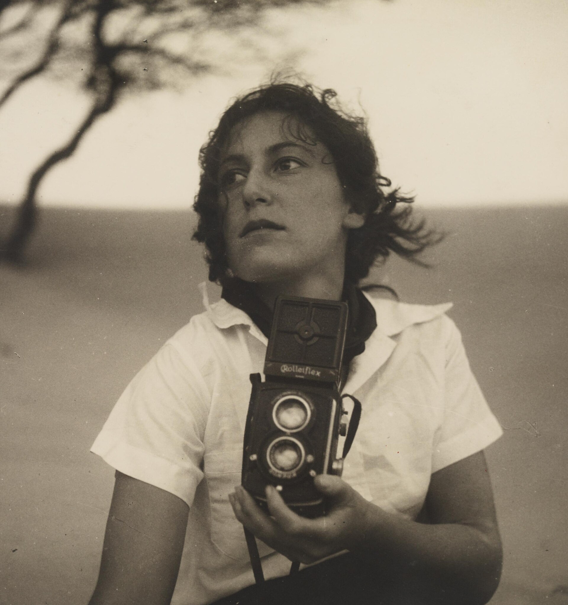 Olive Cotton, holding camera from Camping trips on Culburra Beach by Max Dupain and Olive Cotton (12825579654) (cropped)